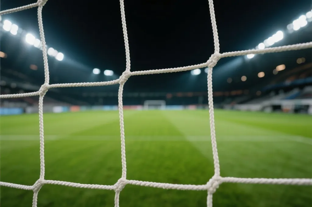 A close-up of a soccer goal net from behind under bright stadium floodlights